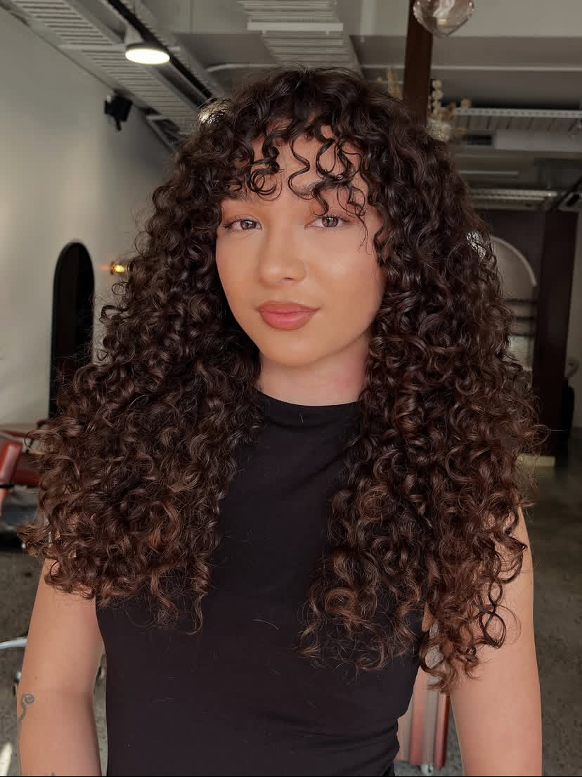 Voluminous Curly Haircut with Bangs